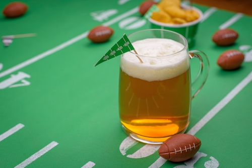 mug of beer on snack table decorated for superbowl party